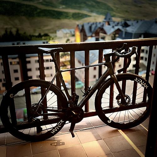 Bicicleta de carretera sobre balcón con vistas a SNO: Aragon Hills nevadas y edificios.
