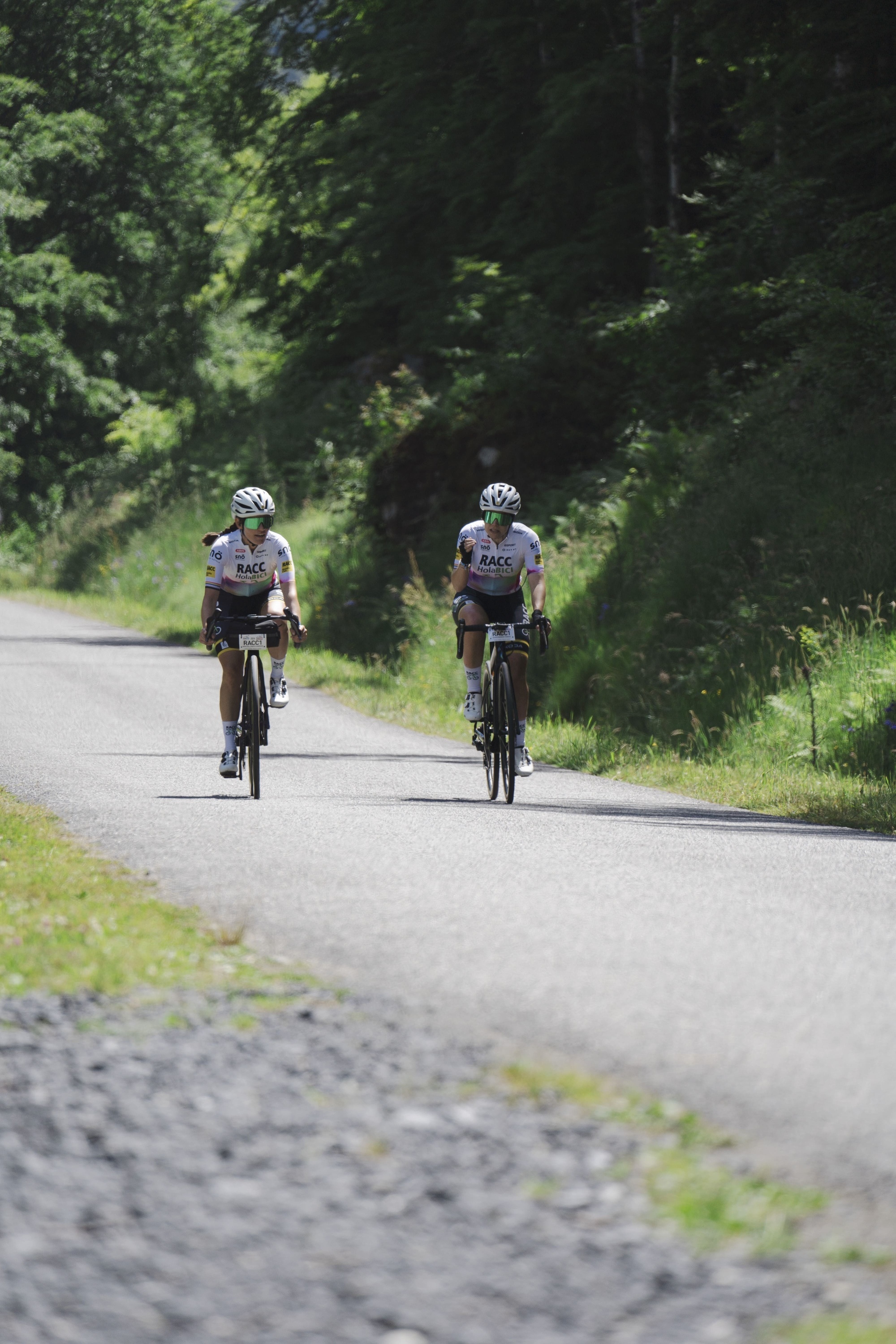 un homme fait du vélo sur une route avec des arbres en arrière-plan