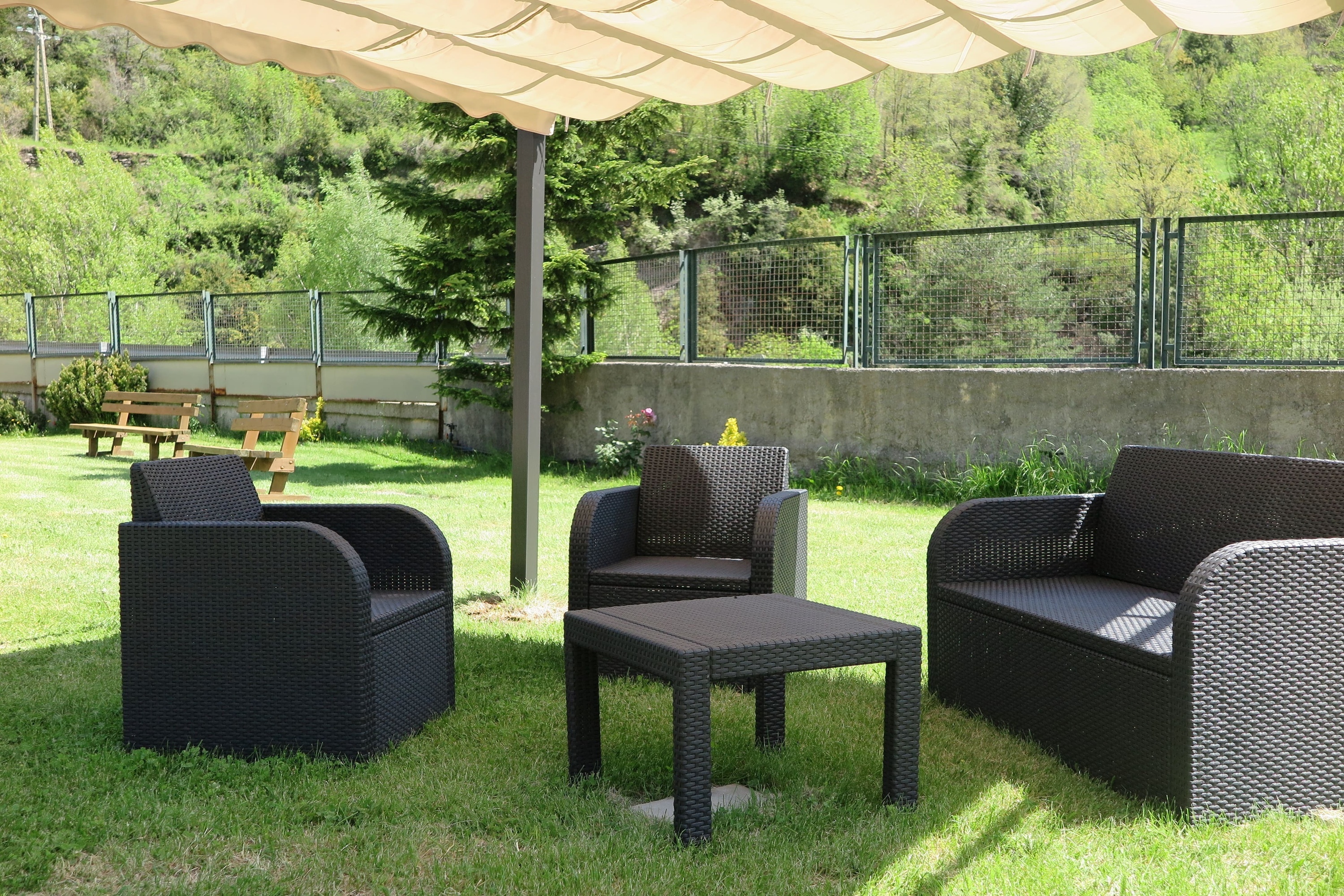 a lawn with chairs and a table under a canopy