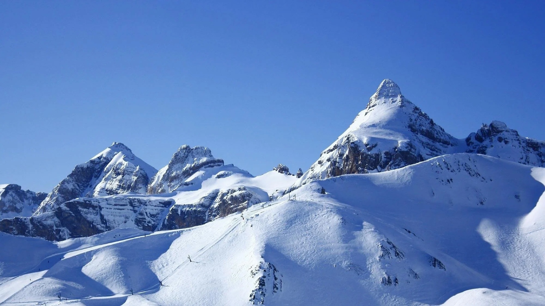 montañas cubiertas de nieve con un cielo azul en el fondo