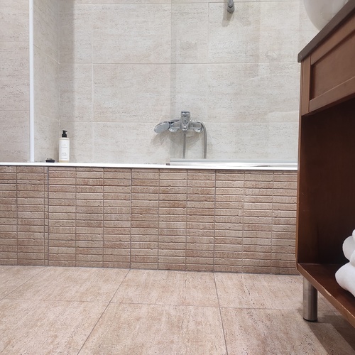 a bathroom with a bathtub and a towel rack