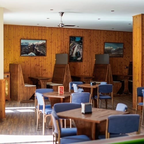 a room with tables and chairs and a pool table