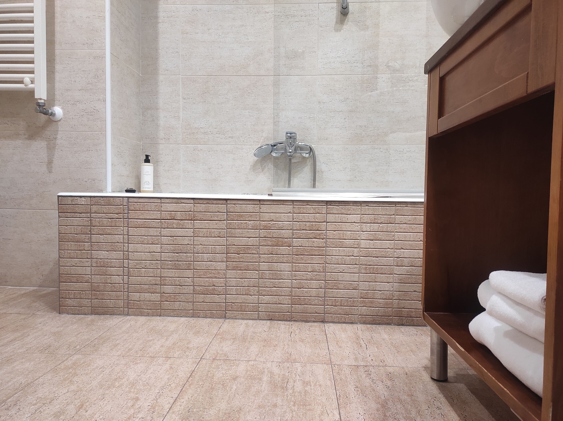 a bathroom with a bathtub and a towel rack