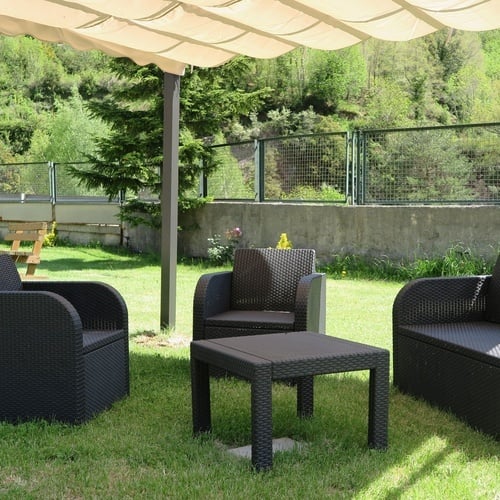 un patio avec des chaises et une table sous un parasol