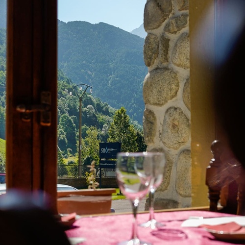 une table avec des verres à vin et une montagne en arrière-plan