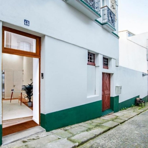 un edificio blanco y verde con la puerta abierta