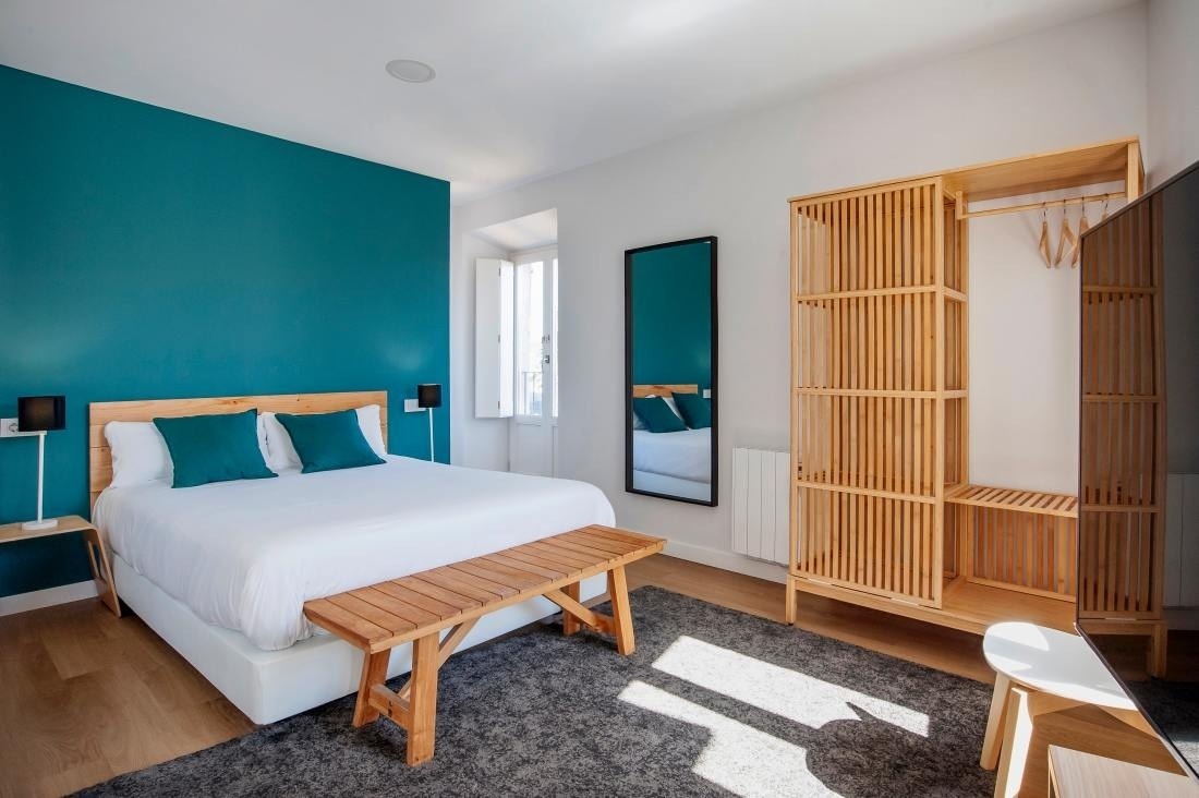 una habitación con una cama y un banco de madera