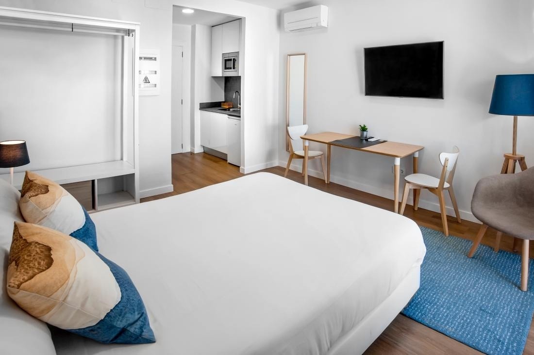 una habitación blanca con una cama y una mesa