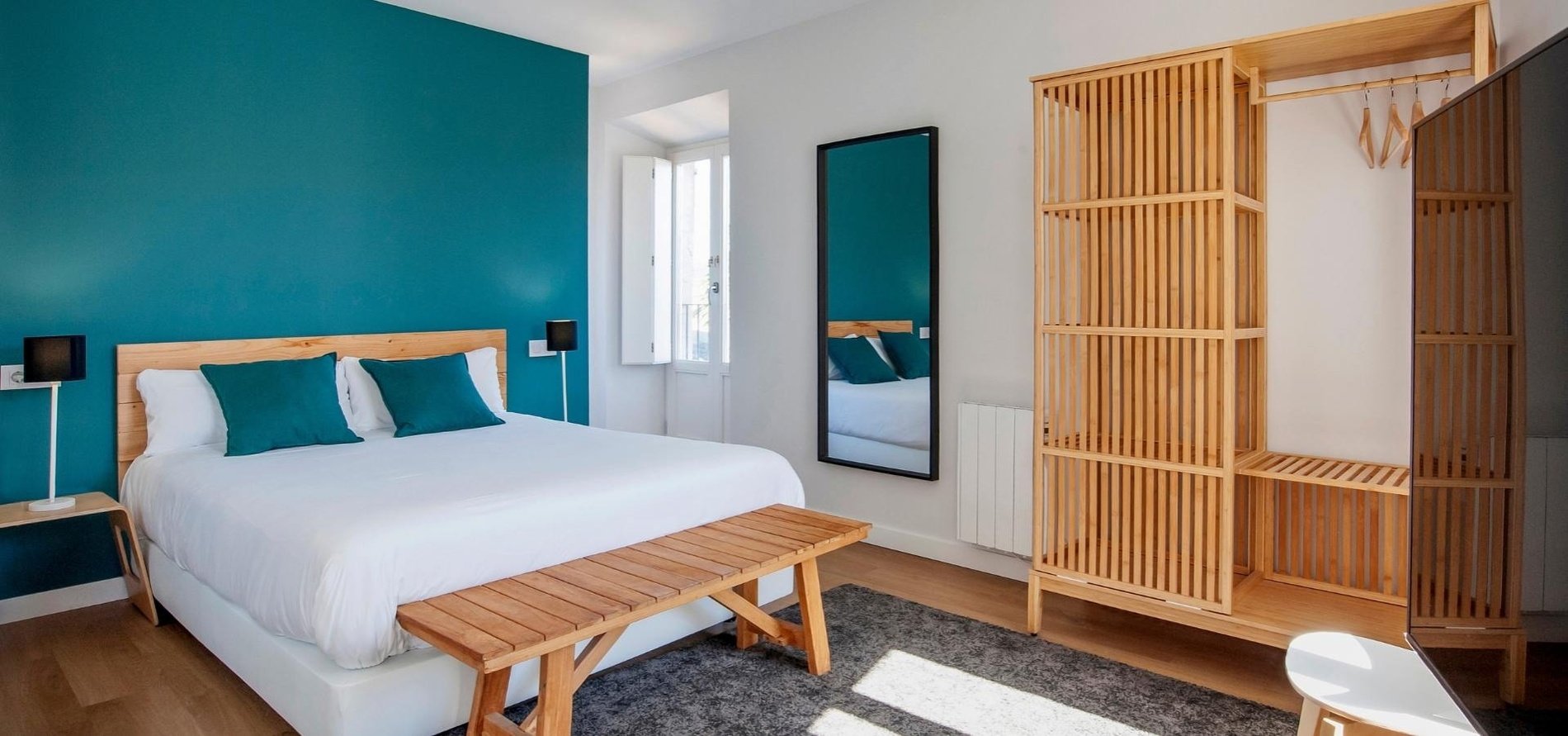 una habitación con una cama y un banco de madera