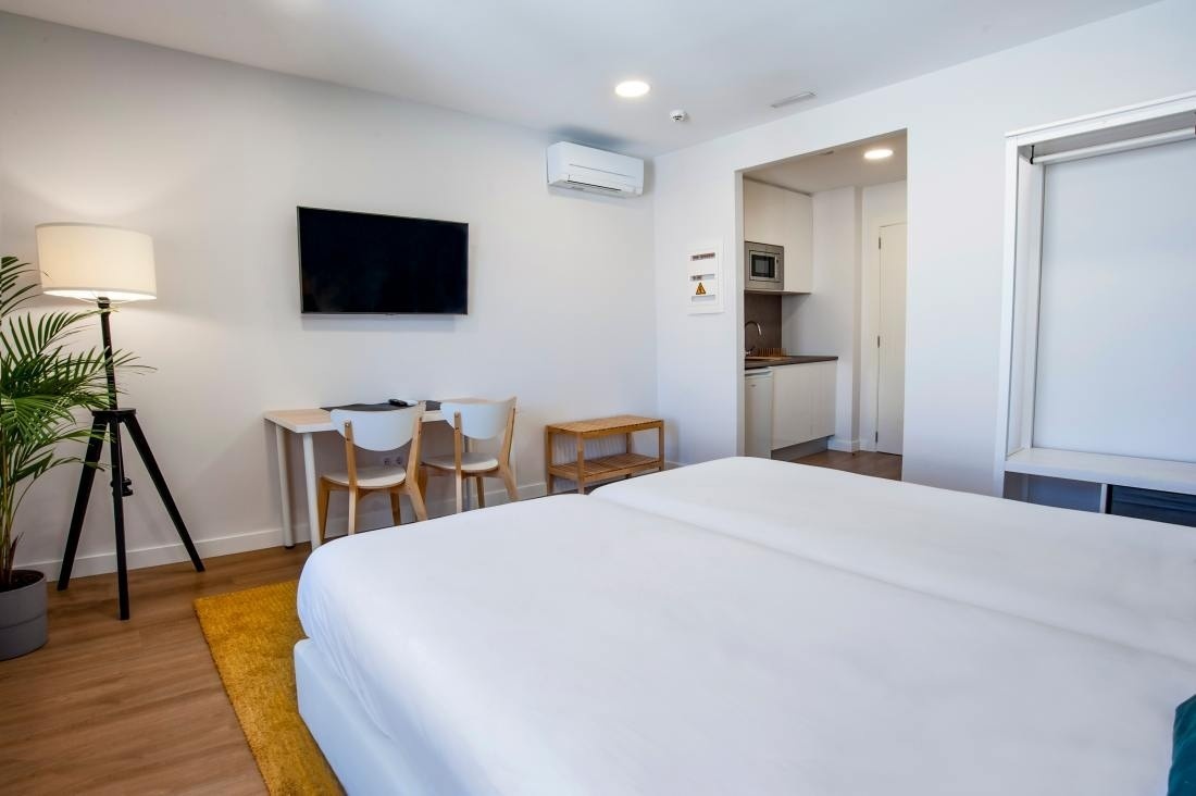 una habitación con una cama y una televisión en la pared