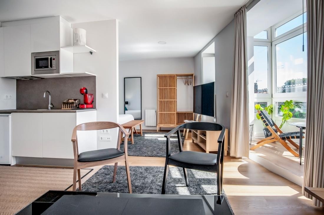 una cocina y una sala de estar con sillas y una mesa