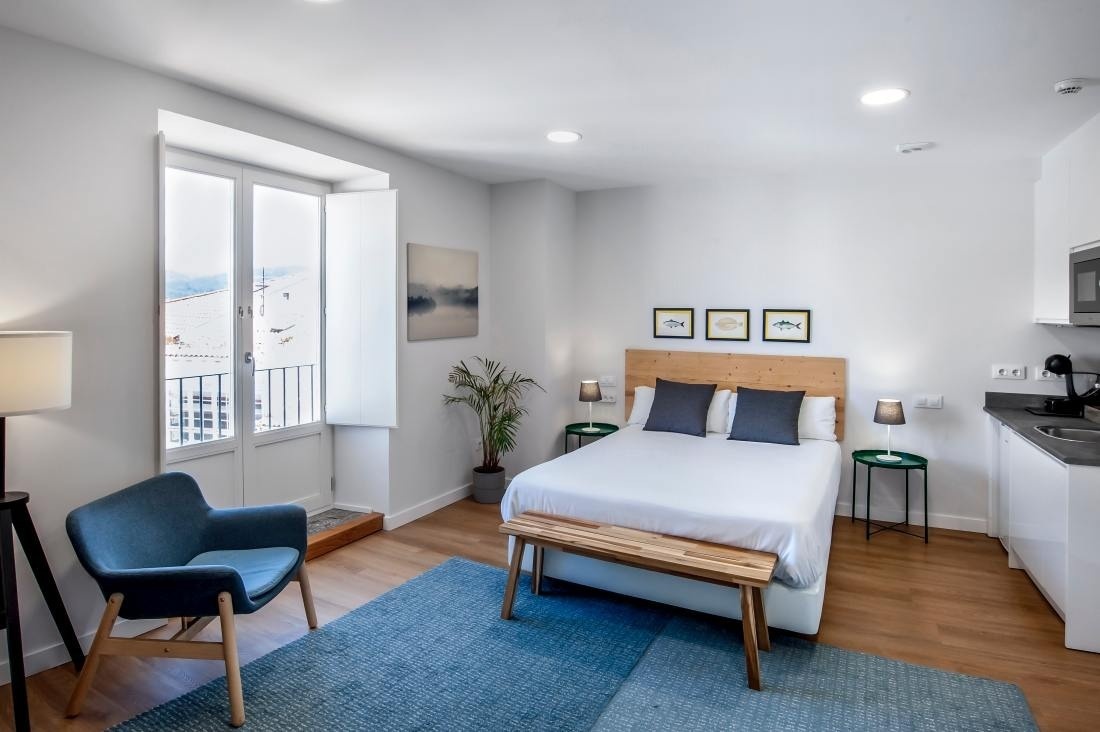una habitación pequeña con una cama y una silla