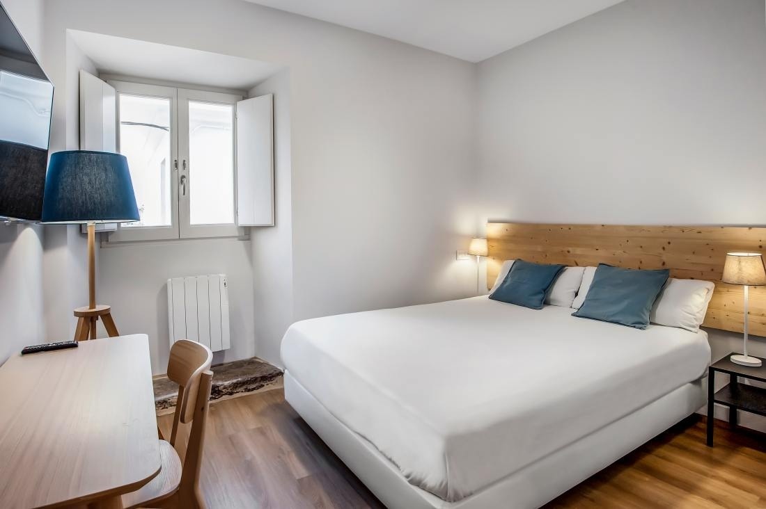 una habitación pequeña con una cama y una mesa