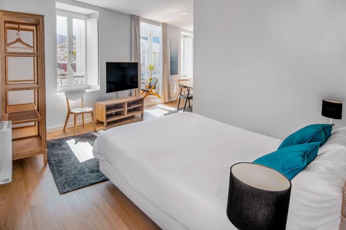 una habitación con una cama y una televisión de pantalla plana