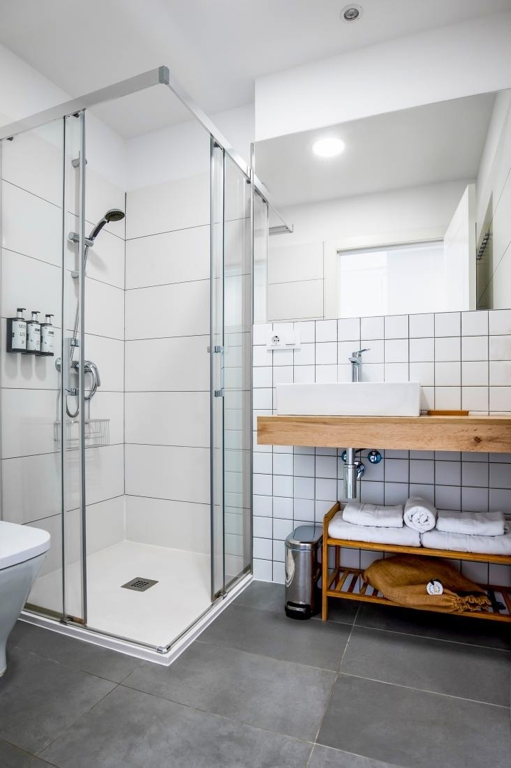 un baño con azulejos blancos y una ducha