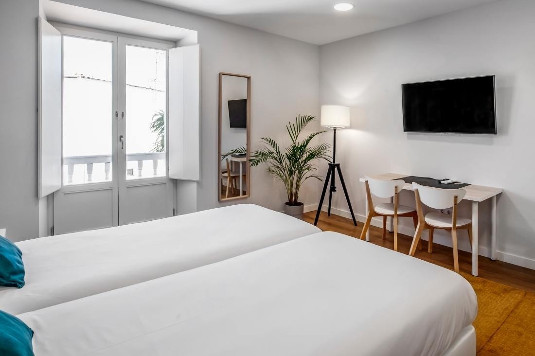 una habitación con dos camas , una mesa y una televisión
