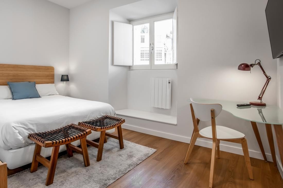 una habitación pequeña con una cama y una mesa