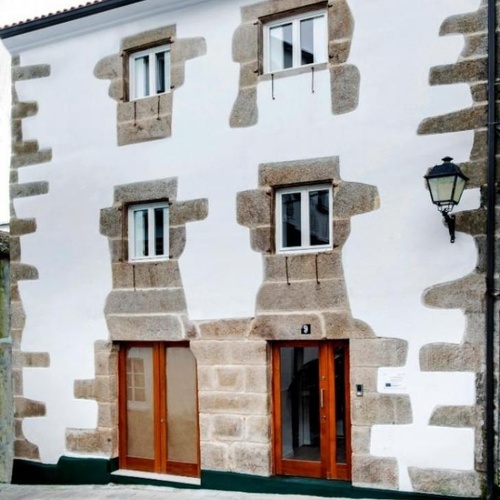 un edificio de ladrillo blanco con una puerta de madera