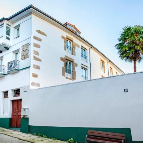 un edificio blanco y verde con el número 16 en la pared