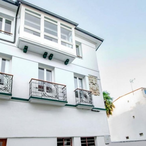 un edificio blanco con balcones y el número 47