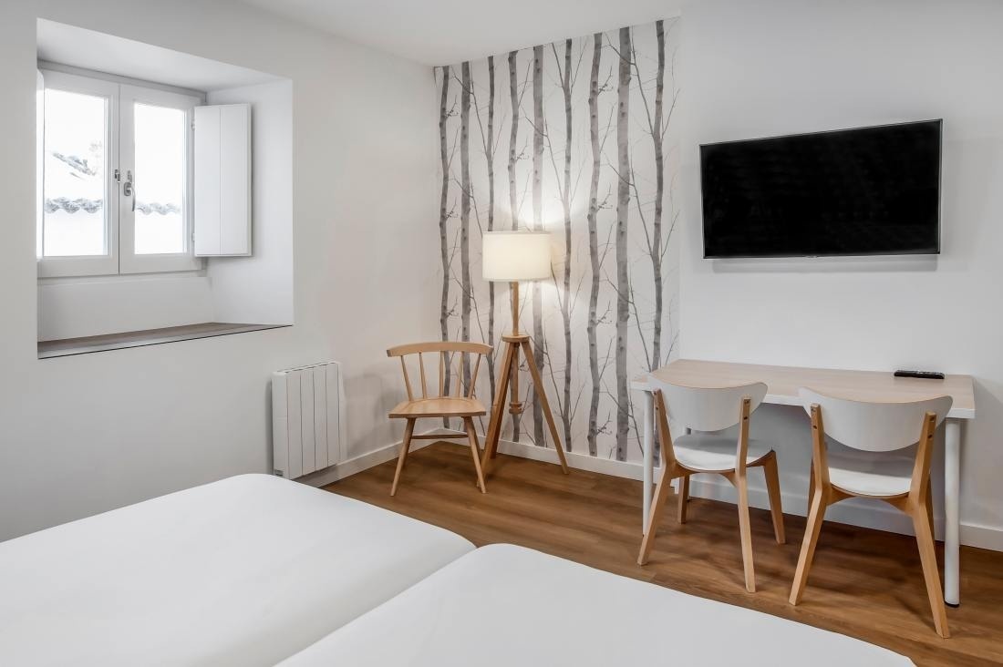 una habitación con dos camas , un escritorio y una televisión
