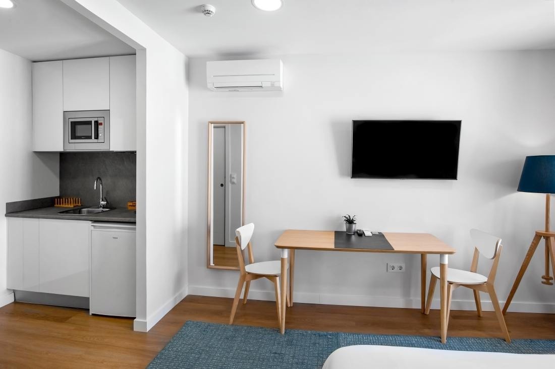 una habitación con una mesa y sillas y una televisión