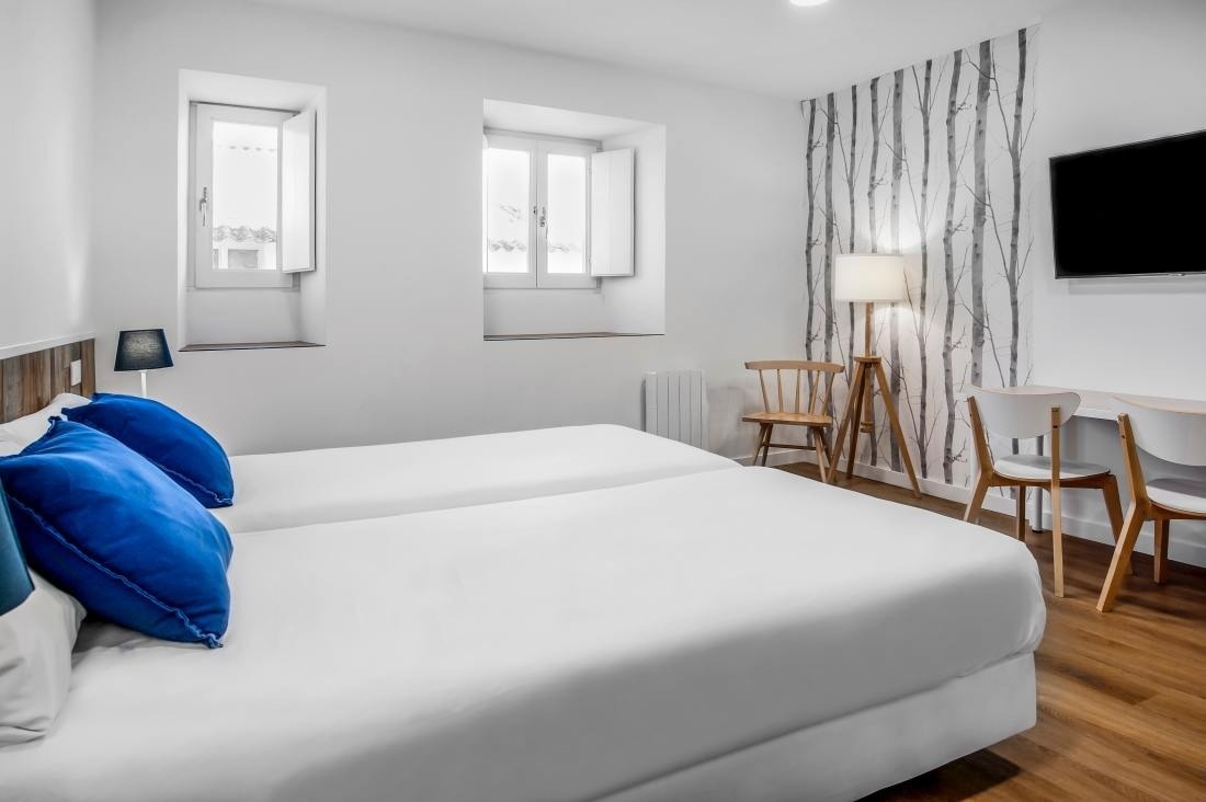 una habitación de hotel con dos camas y una televisión