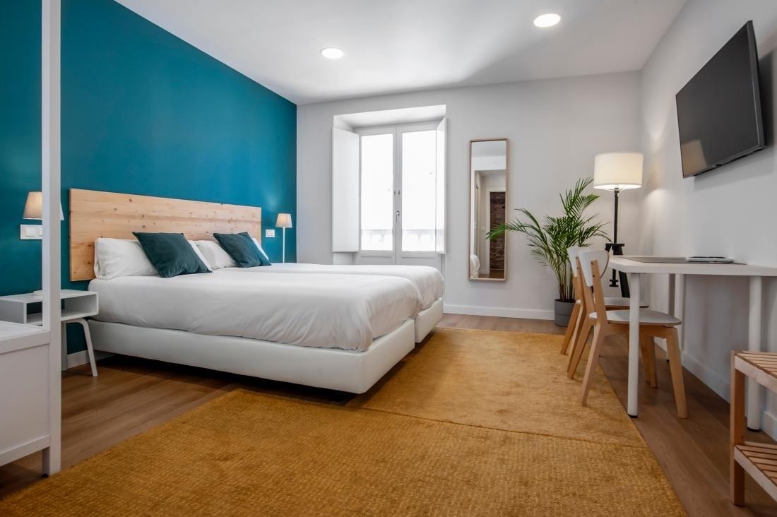 una habitación con dos camas , una mesa y una televisión