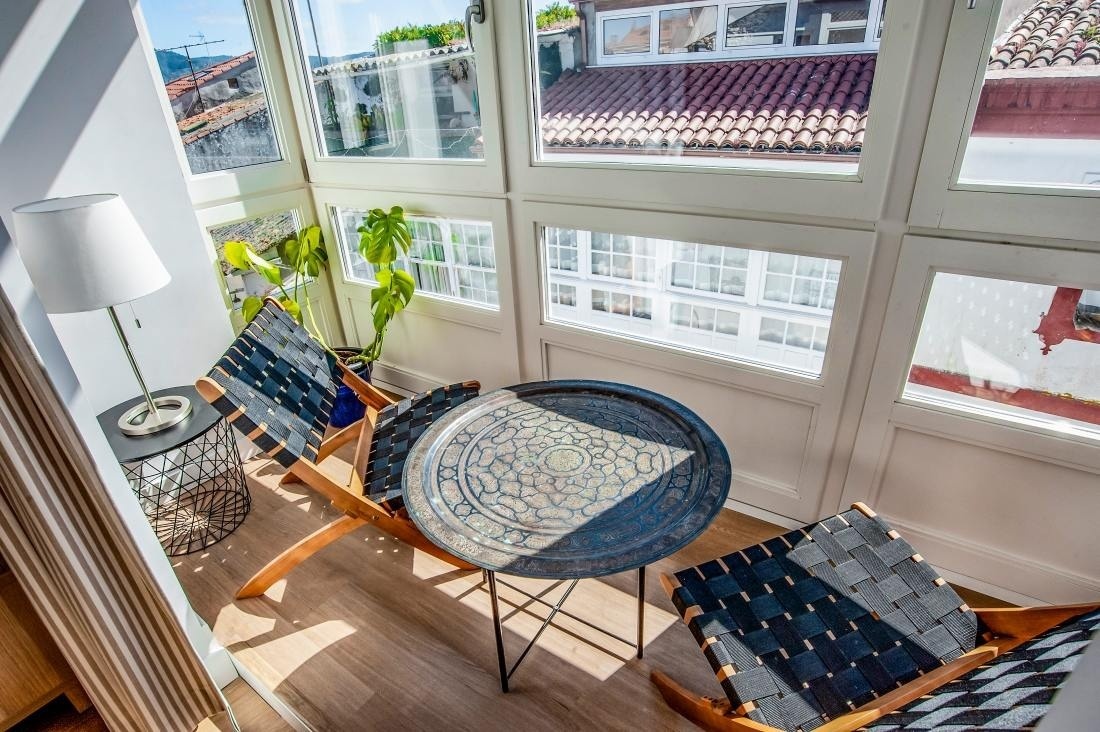 dos sillas y una mesa frente a una ventana