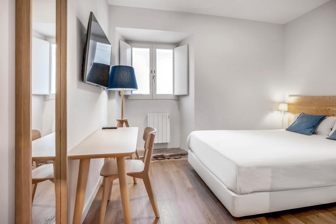 una habitación pequeña con una cama y una mesa