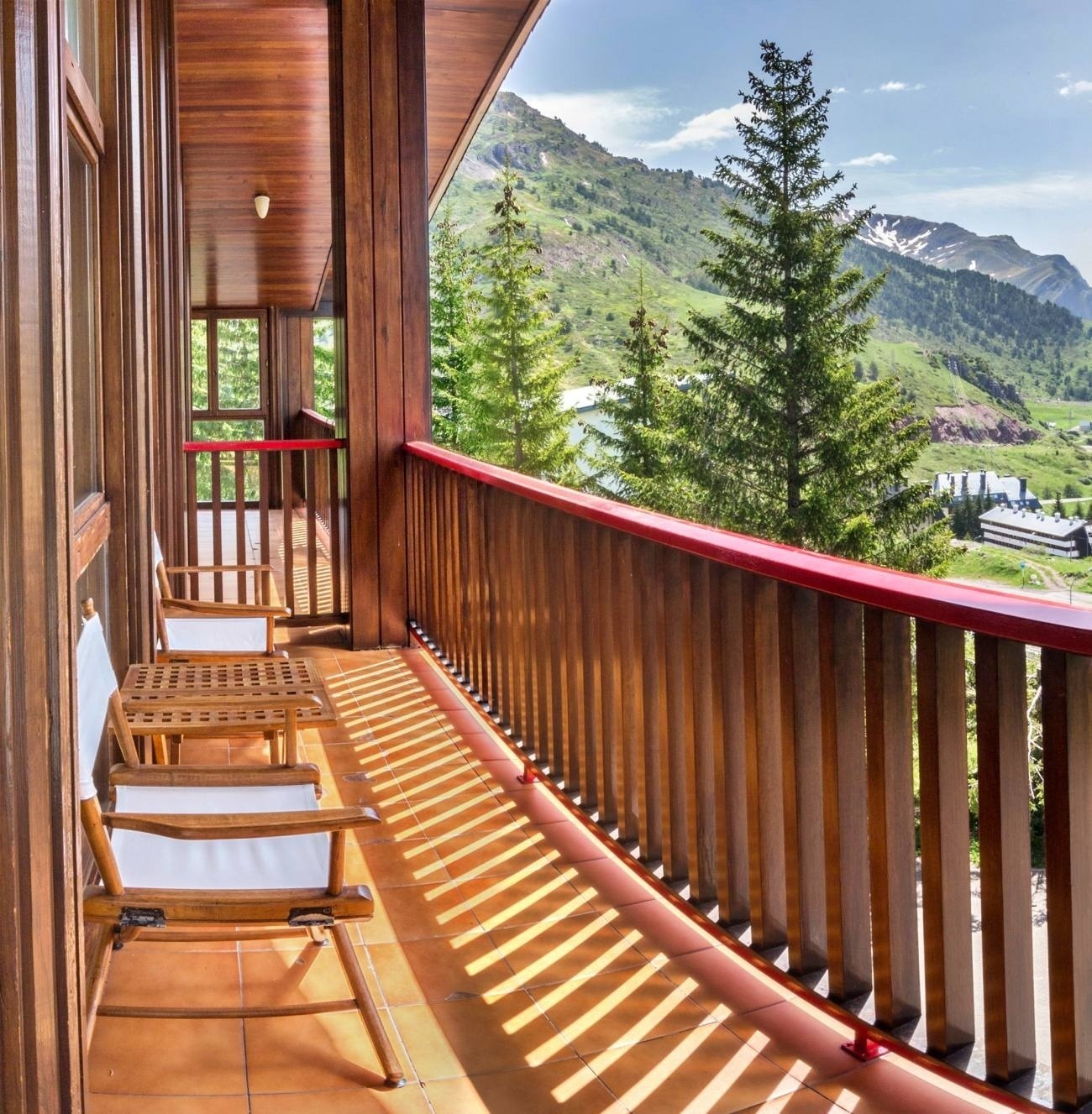 a balcony with a view of mountains and trees