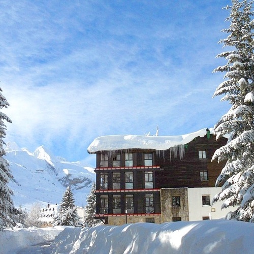 a snowy landscape with a building in the foreground