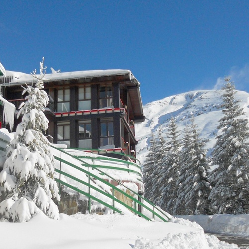 un bâtiment couvert de neige avec la montagne en arrière-plan