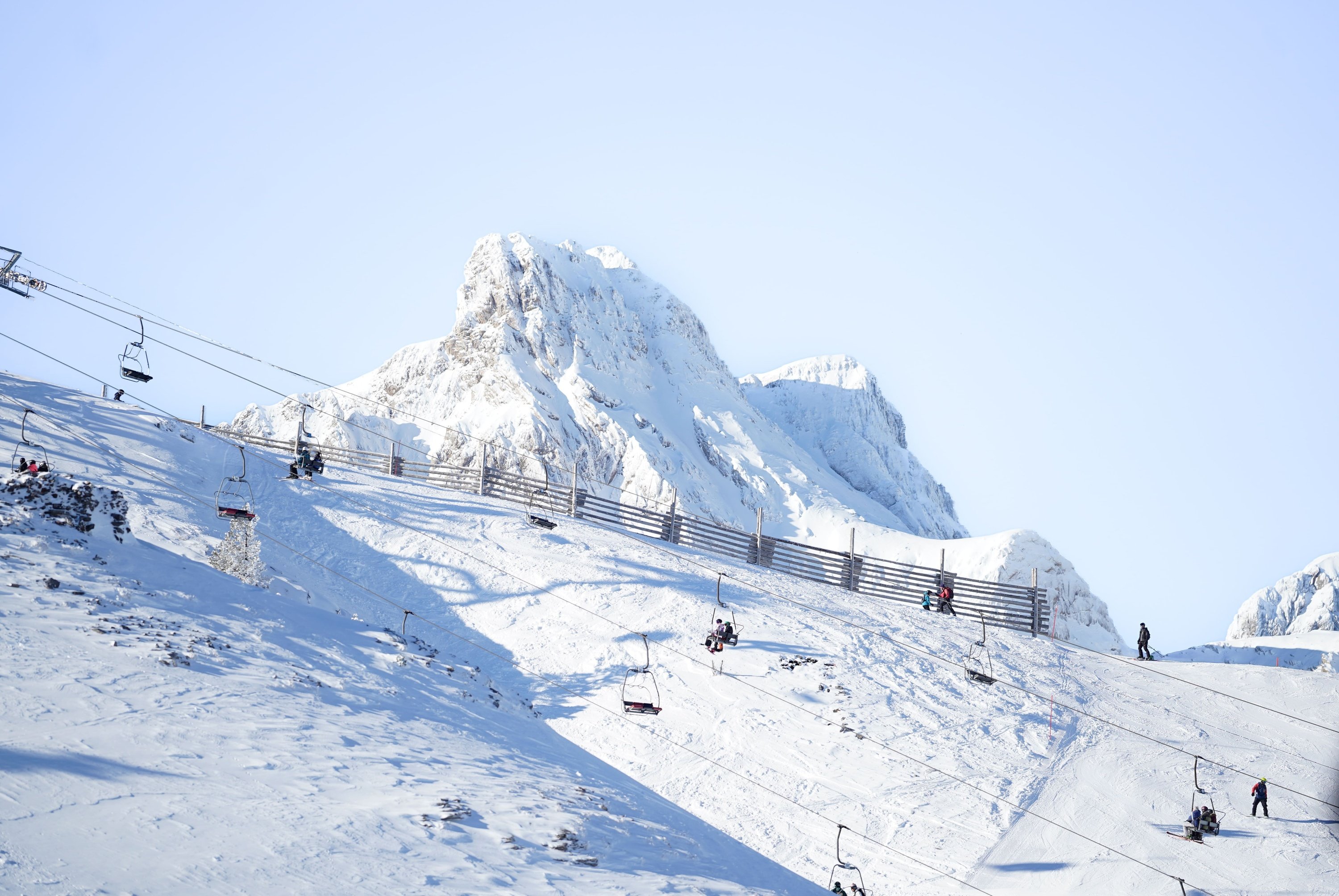 una montaña cubierta de nieve con un teleférico en primer plano