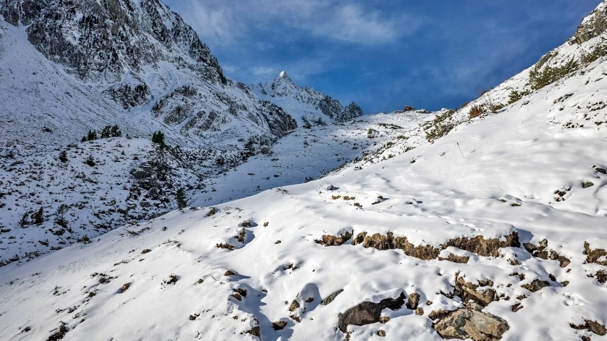 a snowy mountain with a blue sky in the background