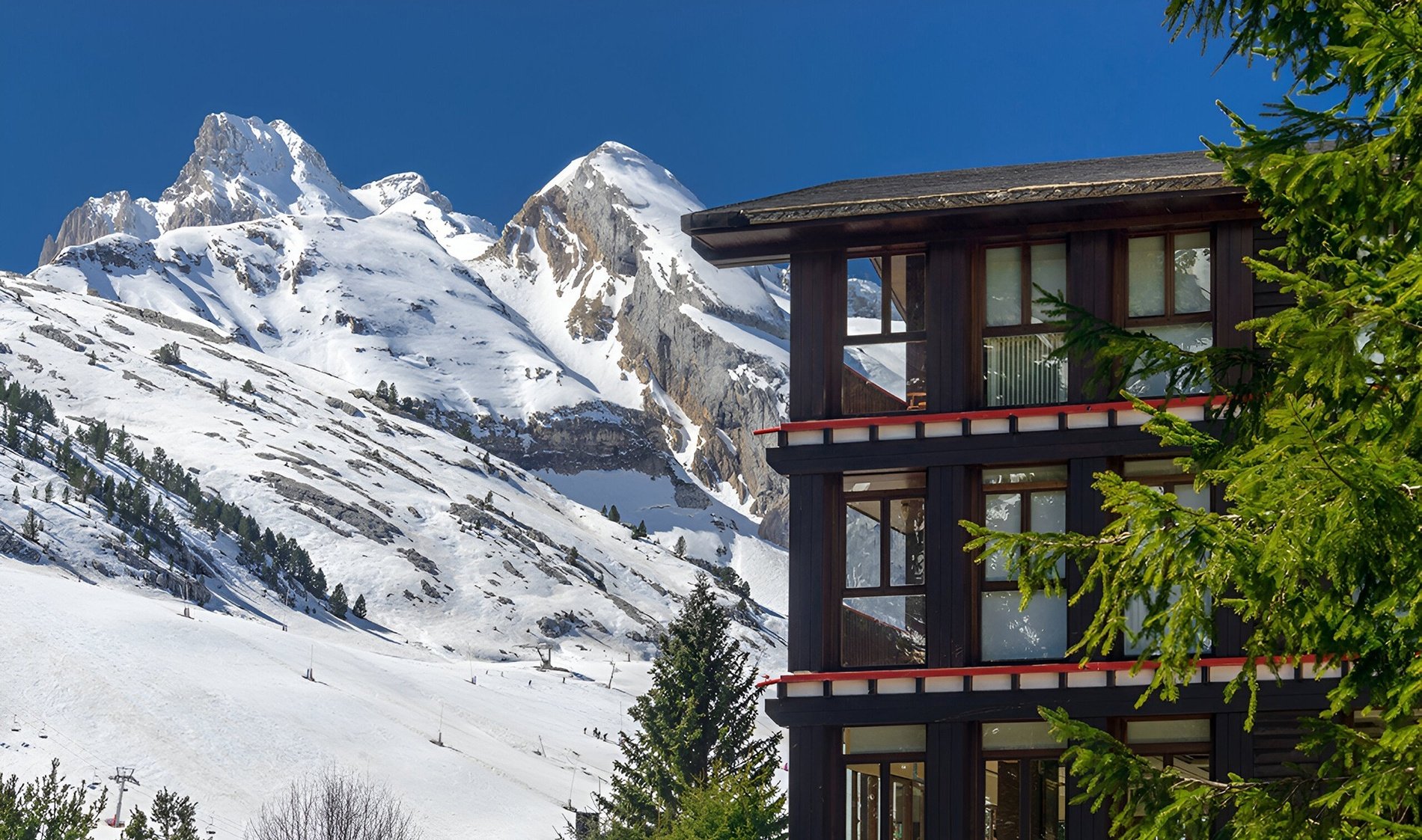 un bâtiment en bois avec des montagnes enneigées en arrière-plan