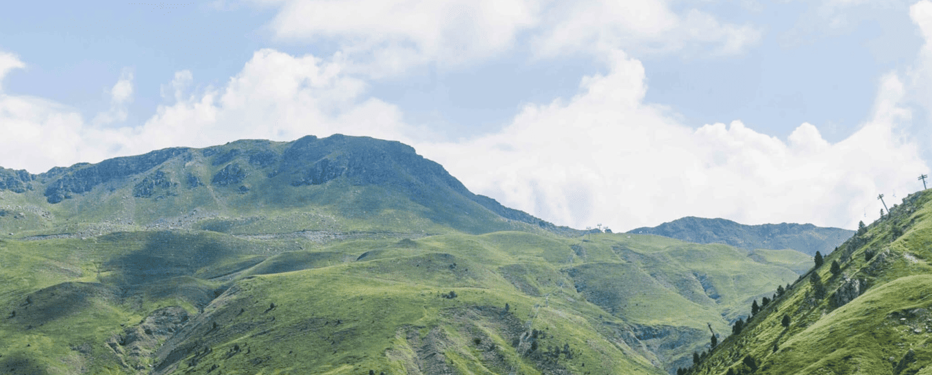 une route serpente à travers une vallée entourée de montagnes