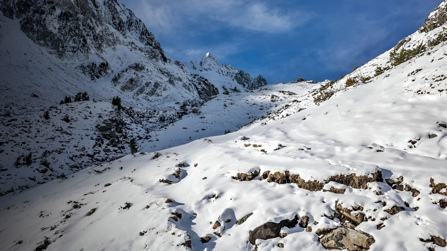 a snowy mountain with a blue sky in the background