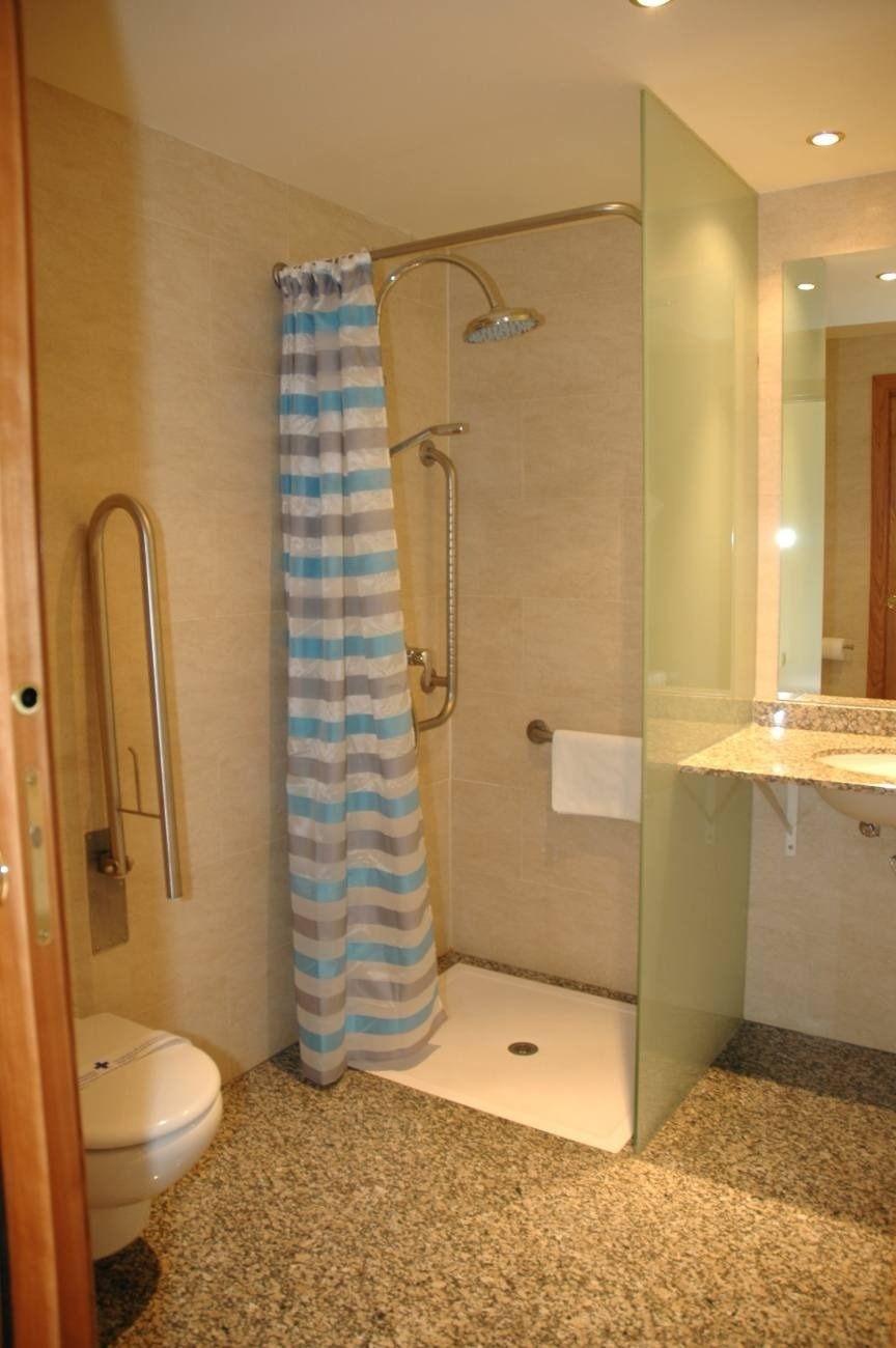 a bathroom with a striped shower curtain and a toilet