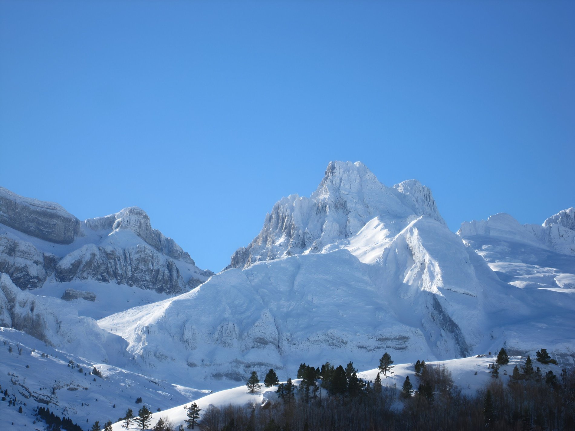 a snowy mountain with a blue sky in the background