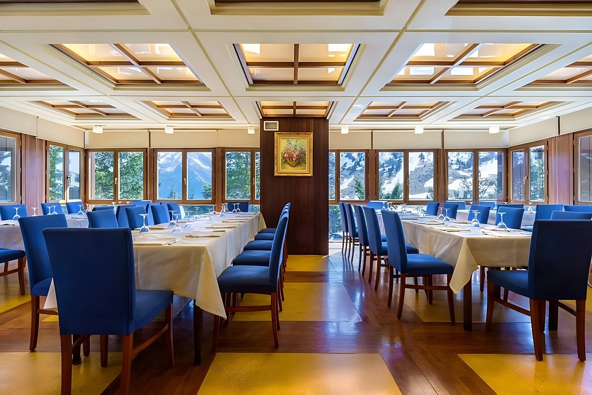 a large room with tables and chairs and a painting on the wall