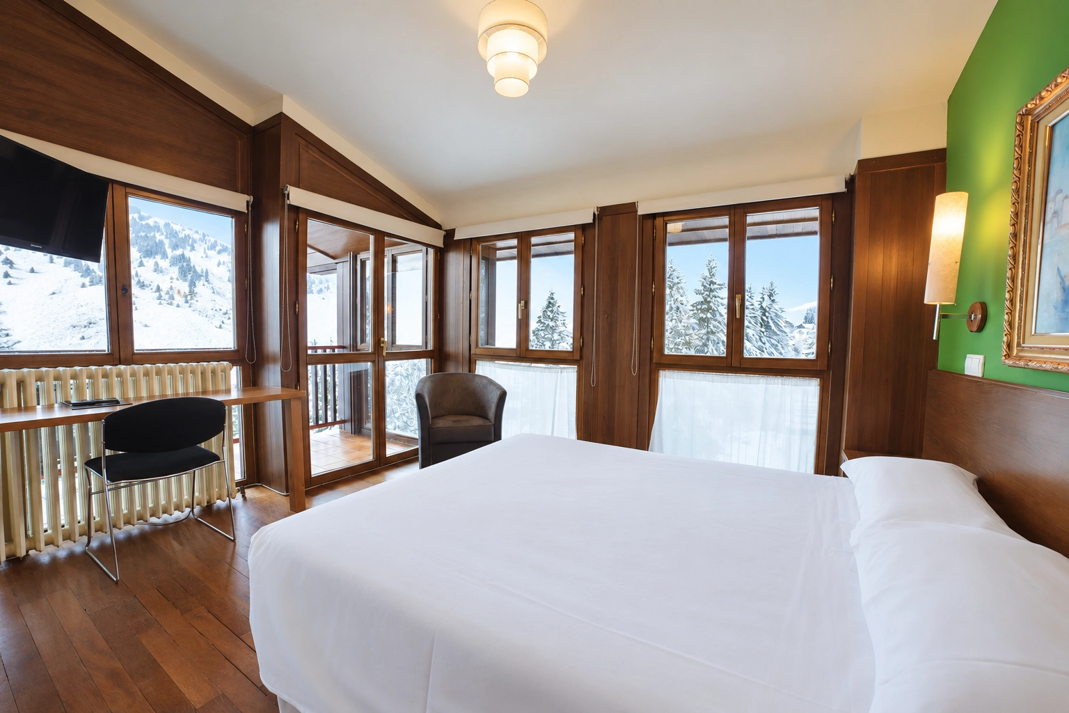 Chambre d'hôtel douillette SNO: Candanchú avec vue sur forêt enneigée.