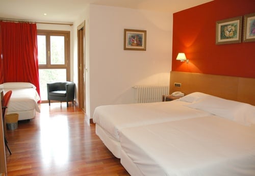 a hotel room with two beds and a chair