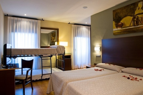 una habitación de hotel con dos camas y una litera