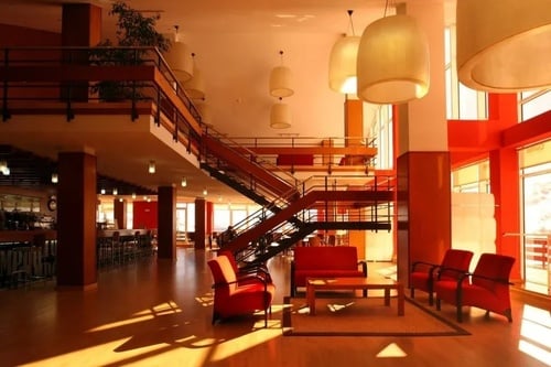 a large room with red chairs and a staircase