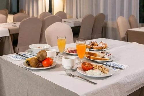 una mesa cubierta con platos de comida y bebidas y una servilleta con la palabra hotel en ella