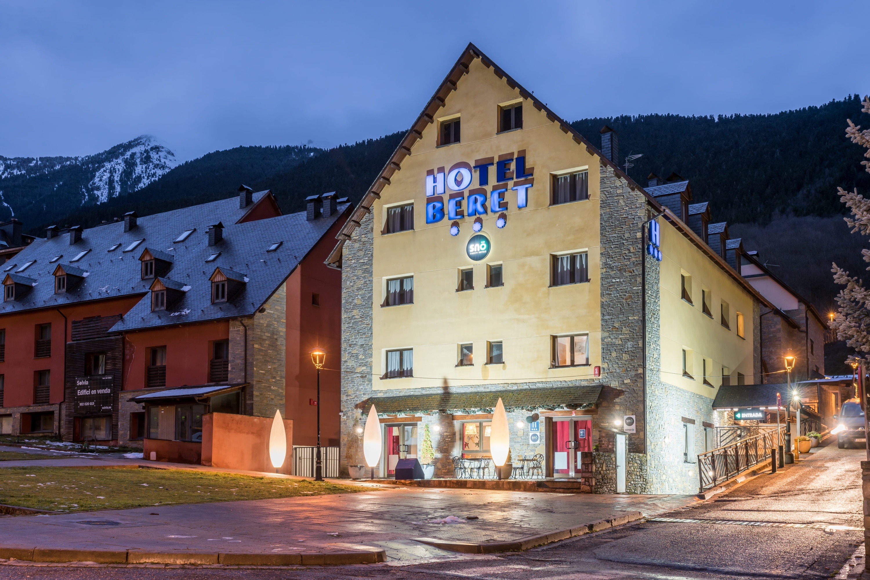 l' hôtel bert est éclairé la nuit