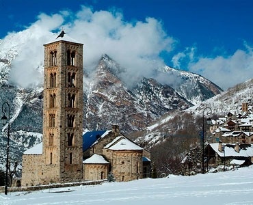 un pueblo en las montañas con flores rosadas en primer plano