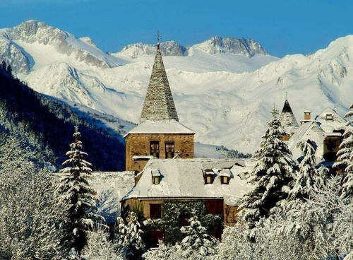 a snowy mountain landscape with a church in the foreground