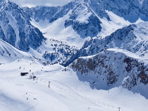 a ski lift is going down a snowy mountain